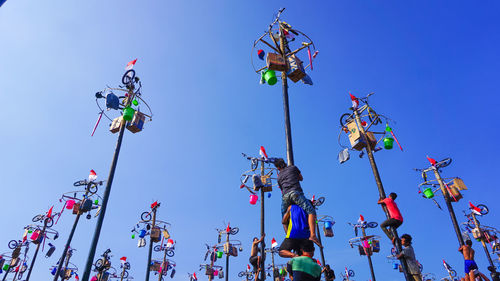 Low angle view of lanterns hanging against clear blue sky