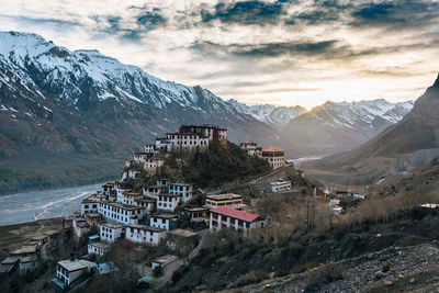 Scenic view of townscape by mountains against sky