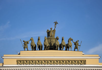 Low angle view of statue against blue sky. the triumphal chariot on the arch. st. petersburg. russia