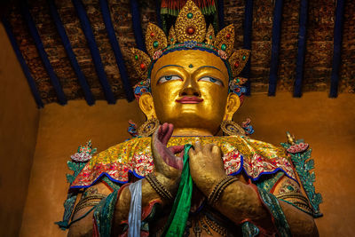 Close-up of buddha statue against building