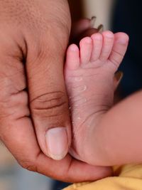 Cropped hand holding baby foot