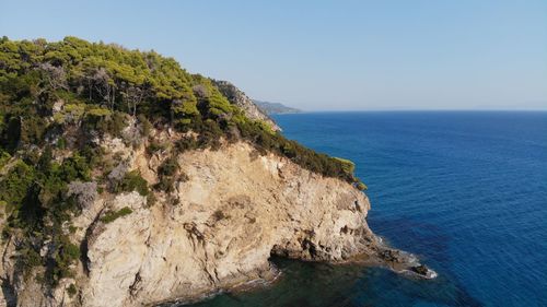 Rock formations by sea against sky