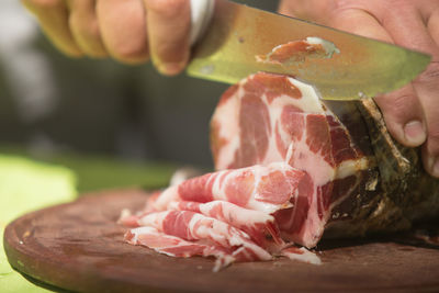 Cropped image of hand cutting meat