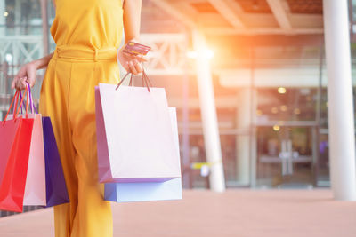 Rear view of woman holding umbrella at store