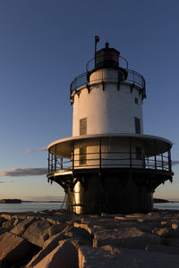 Lighthouse on sea against clear sky