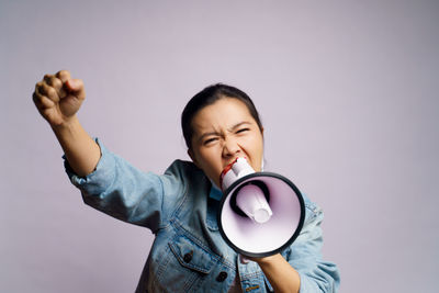 Young women wearing face mask against wall