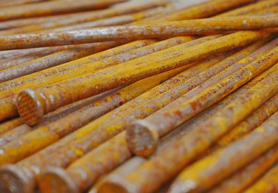 Texture of a group of rusty nails resting on a wooden surface on a construction site.