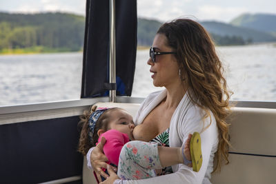 Mother and daughter feeding while standing outdoors