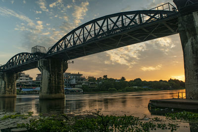 Bridge over river against sky during sunset