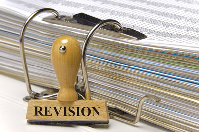 Close-up of revision stamp by documents on table