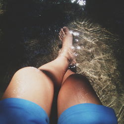 Low section of woman in shallow water at pond