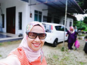 Portrait of smiling young woman wearing sunglasses