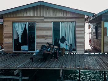 People sitting on bench against building