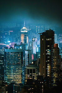 Illuminated buildings in city against sky at night