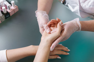 Manicurist does professional light hand massage after manicure procedure.