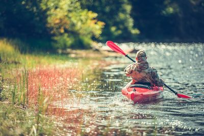 Rear view of man kayaking in lake