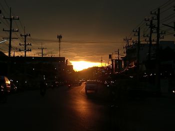Cars on street in city during sunset