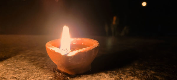 Close-up of lit candle on table