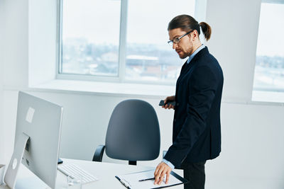 Mid adult man using mobile phone at table