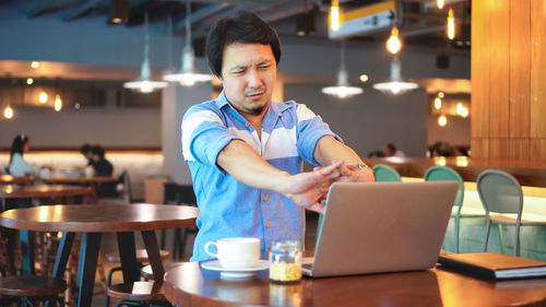 Man using laptop in restaurant