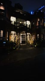 Illuminated street amidst buildings in city at night