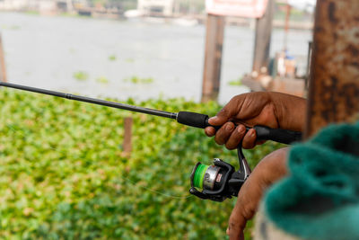Close-up of hand holding fishing rod