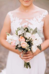 Midsection of woman holding flower bouquet