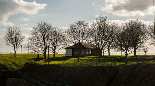 View of field against cloudy sky