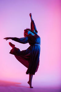 Midsection of woman dancing against white background