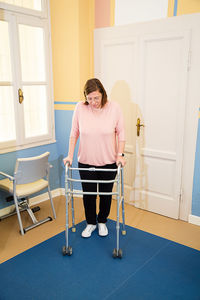 Full length of woman with mobility walker at home