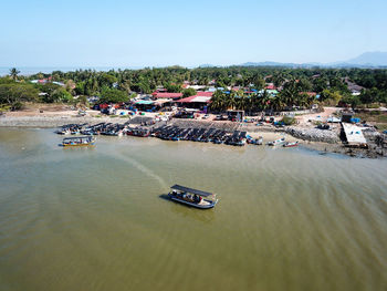 High angle view of buildings by sea against clear sky