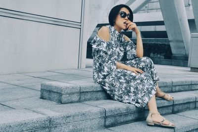 Full length of woman sitting on staircase