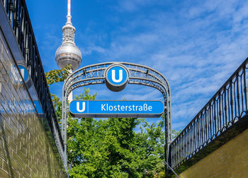 Low angle view of information sign against blue sky