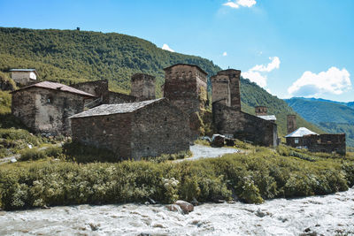 Old building by mountain against sky