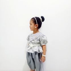 Portrait of child dressed in traditional thai costumes standing against white background