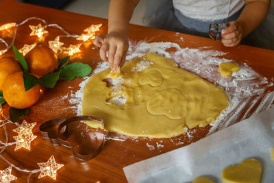 Midsection of girl making gingerbread cookies at home