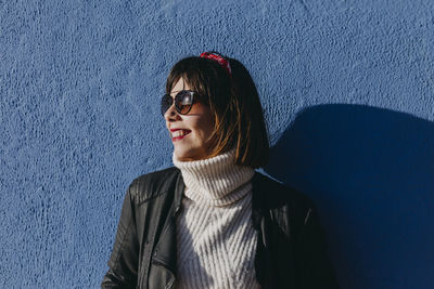Portrait of smiling woman against wall