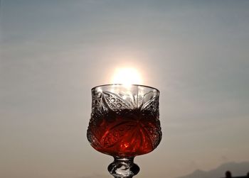 Close-up of wine glass against sunset