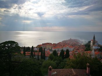 Scenic view of sea by buildings against sky