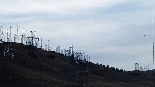 Electricity pylon on mountain against sky