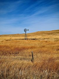 Scenic view of field and windmill against sky