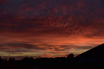 Silhouette houses against sky during sunset