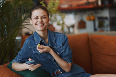 Portrait of young man sitting on sofa