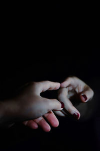 Close-up of woman hand over black background