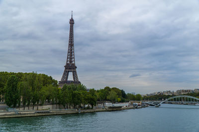 Tower by lake against sky in city