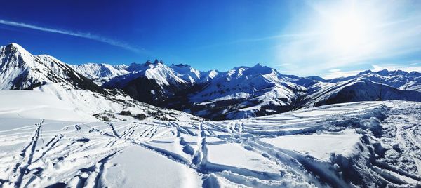 Scenic view of snowcapped mountains against blue sky