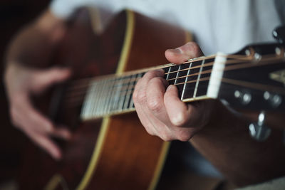 View of human hands playing guitar