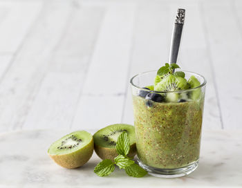 A creamy kiwi chia pudding topped with kiwi slices and blueberries.