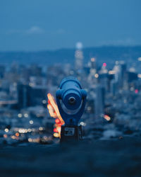 Close-up of illuminated lighting equipment on sea against sky