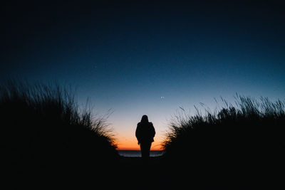 Silhouette woman standing against clear sky during sunset